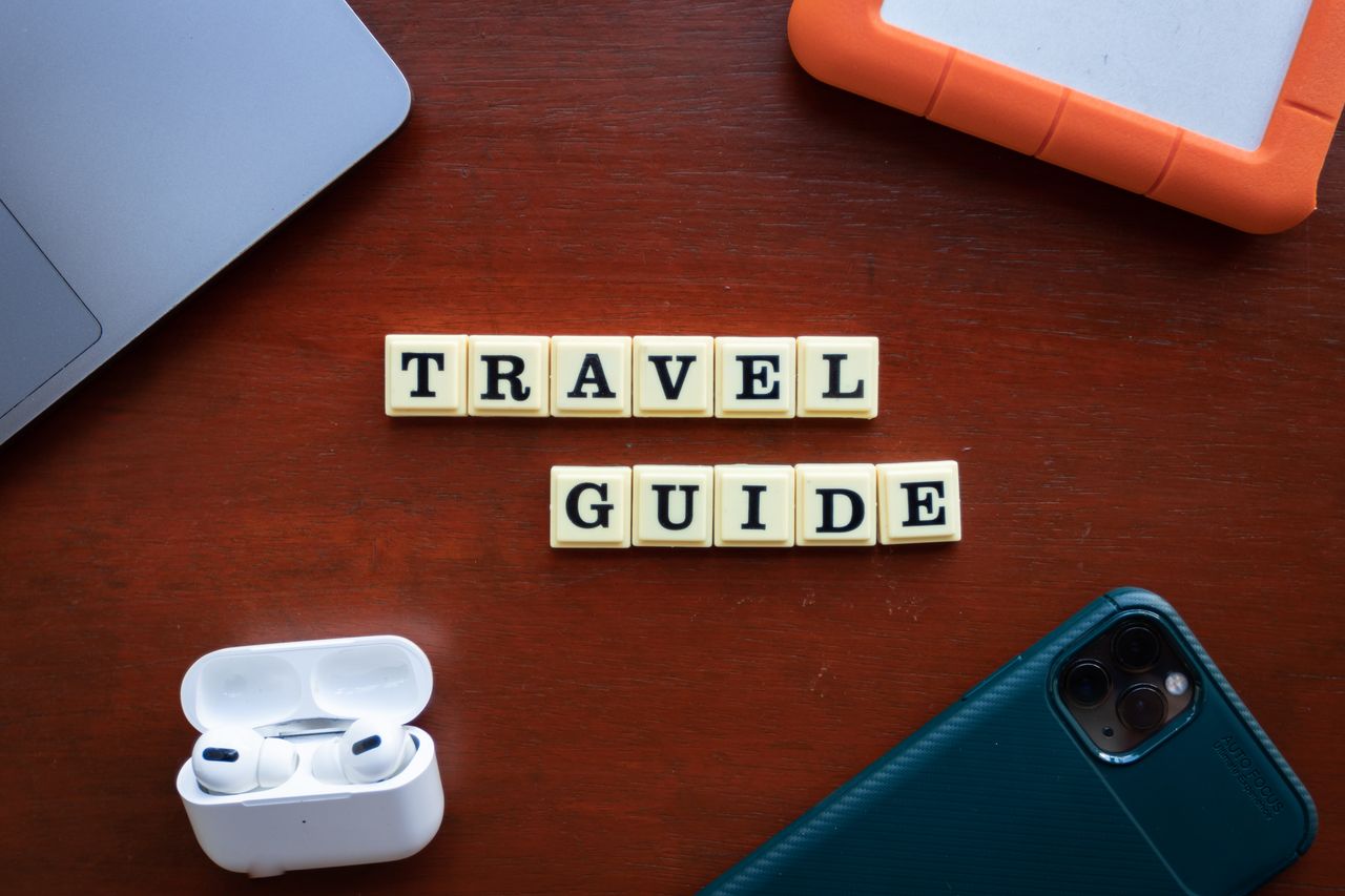 services-05 Flat lay of travel guide concept with smartphone, laptop, and headphones.