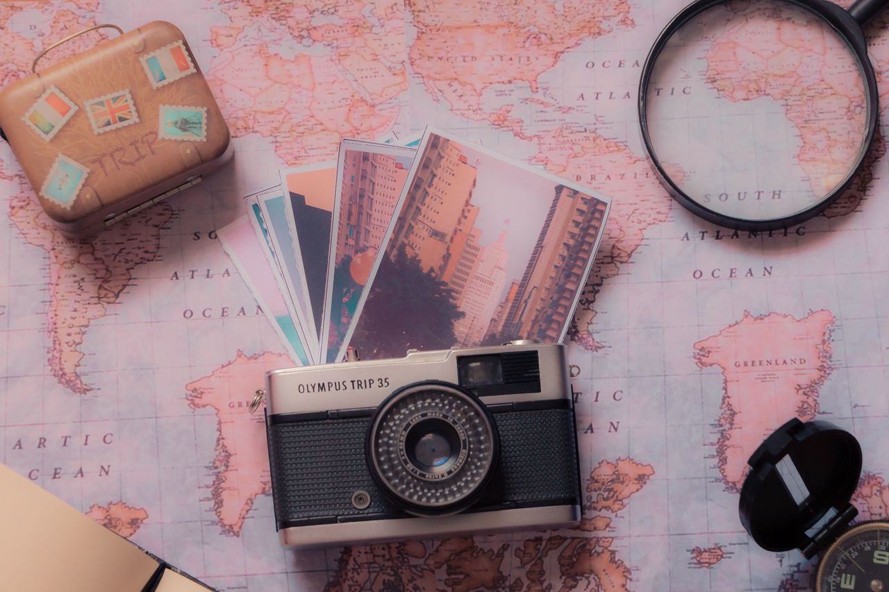 why-choose-us Explore vintage photography with a classic camera and travel-themed setup over a world map.
