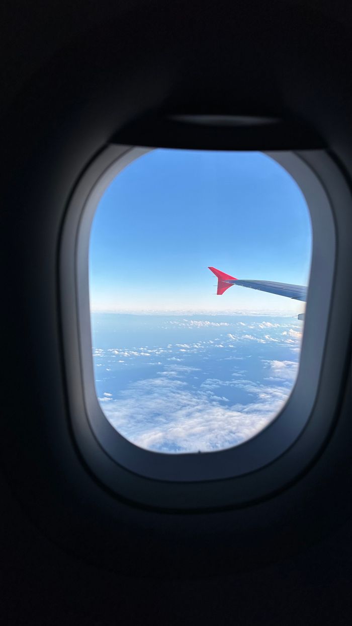 home-hero View from airplane window showing clouds and sky. Perfect for travel themes.